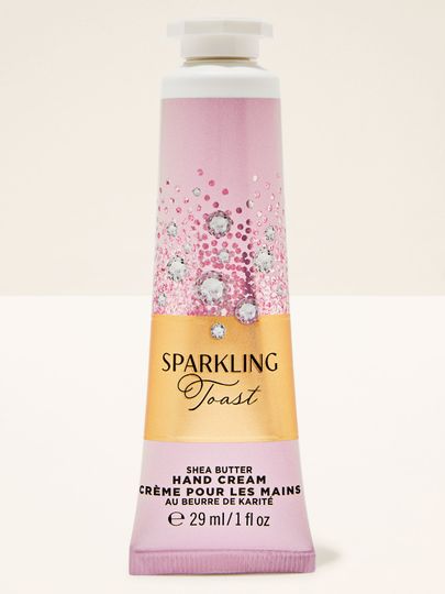Krém na ruce Sparkling Toast Bath & Body Works v růžovo‑zlaté tubě s třpytivou etiketou