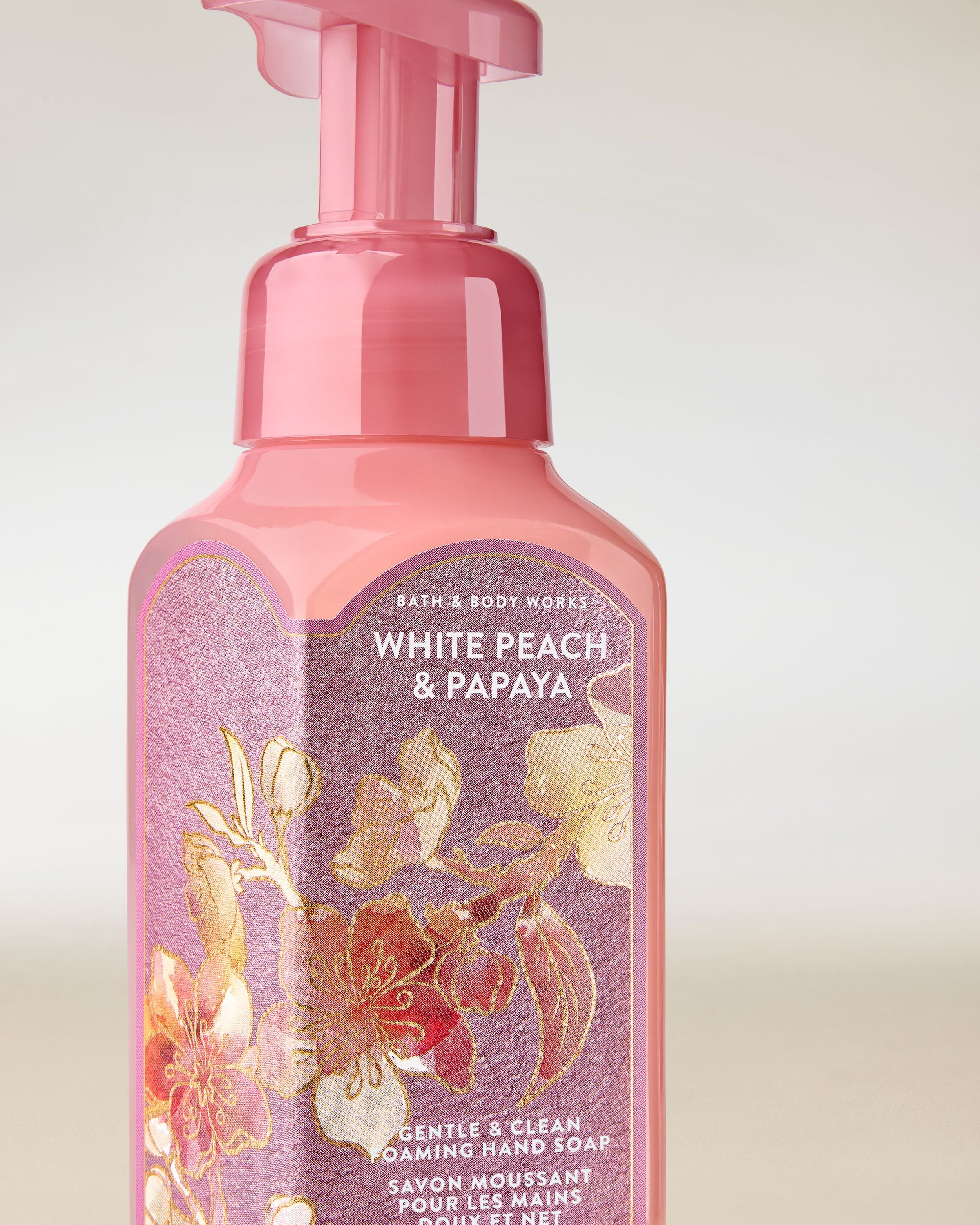 Pěna na ruce Bath & Body Works „White Peach & Papaya” — růžová láhev s květinami.