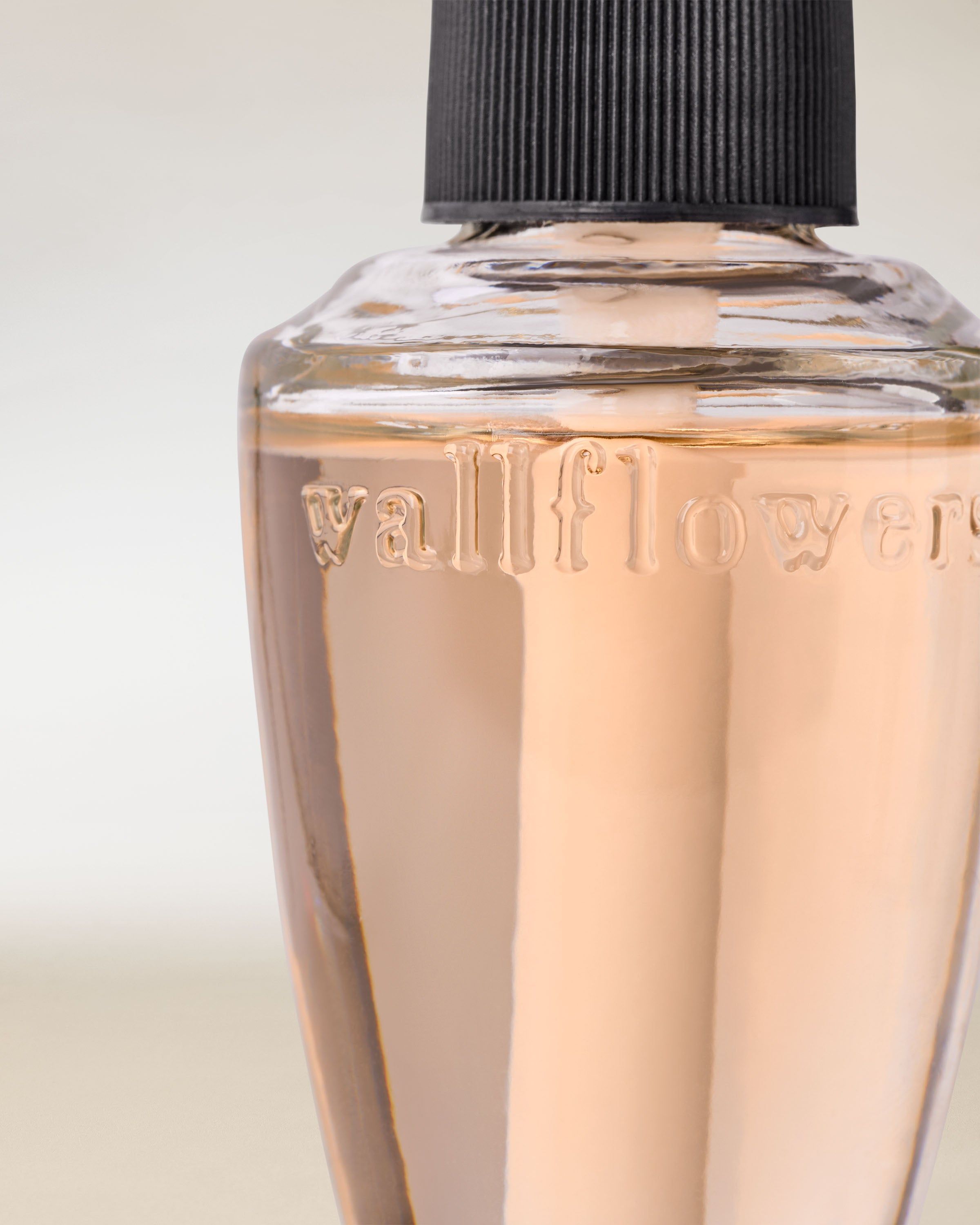 Náplň Wallflowers s růžovou tekutinou v elegantní skleněné lahvičce pro vůni domova.