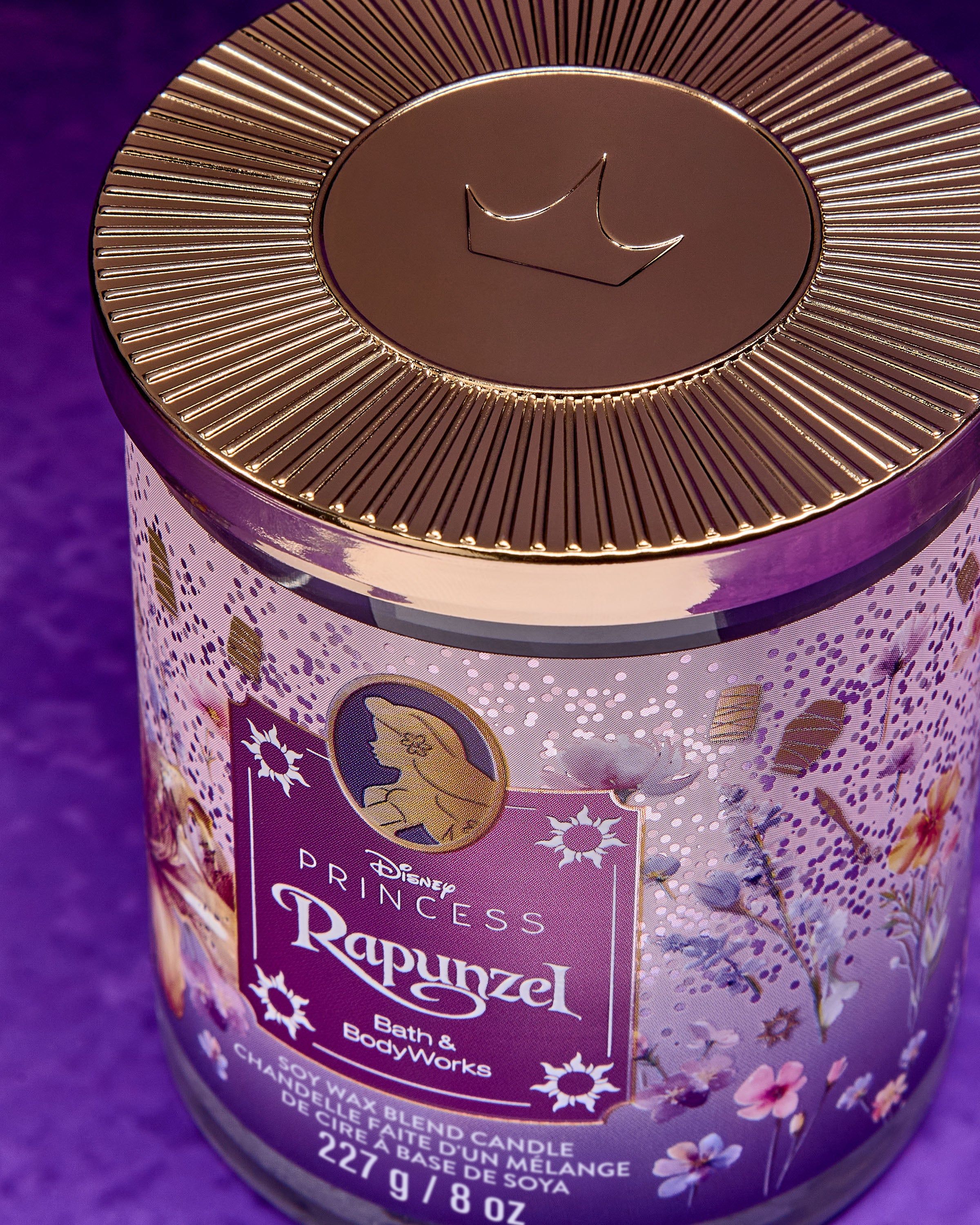 Svíčka Rapunzel z kolekce Disney Princess — fialový motiv s květinami a lucernami v pohádkovém stylu.