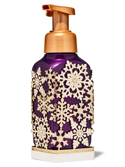 Złote etui na mydło do rąk ozdobione motywem płatków śniegu, z fioletowym mydłem w środku, Bath & Body Works.