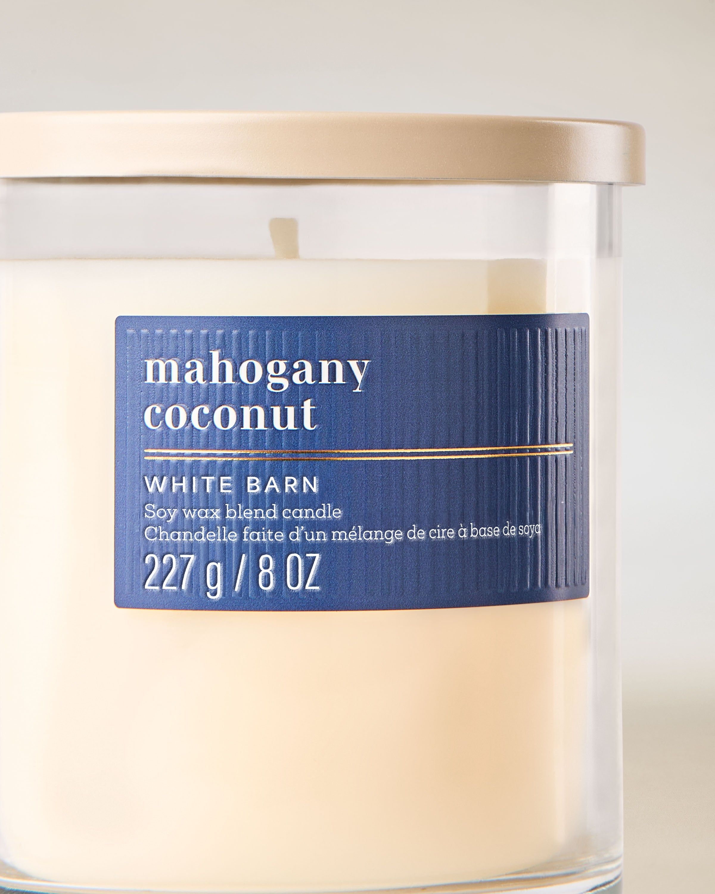 Svíčka Mahogany Coconut White Barn s hřejivou dřevitou vůní a krémovým kokosem.