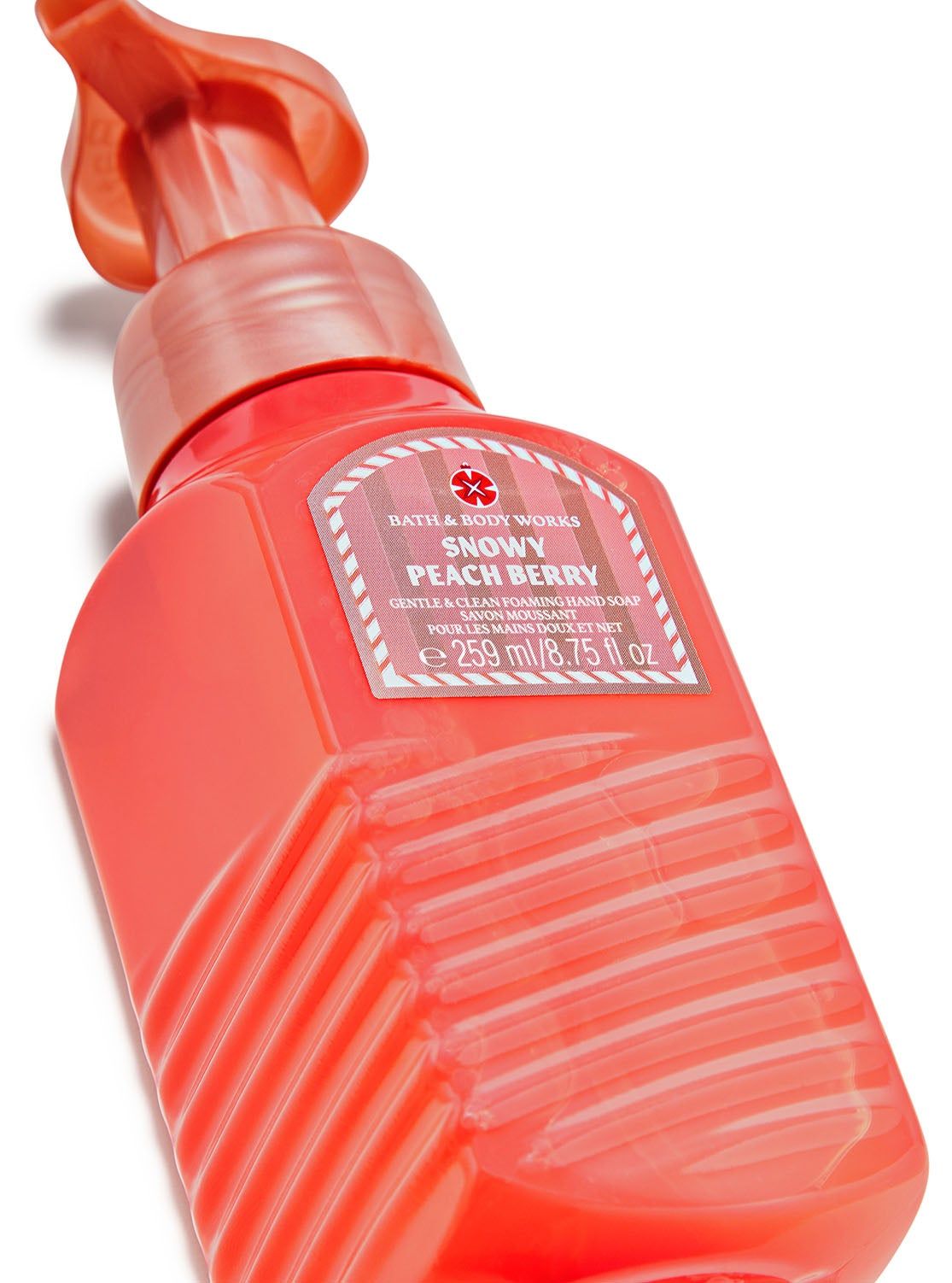 Mydło do rąk w piance Snowy Peach Berry w pomarańczowo-różowej butelce z etykietą z gałązką i płatkiem śniegu. Bath&Body Works.
