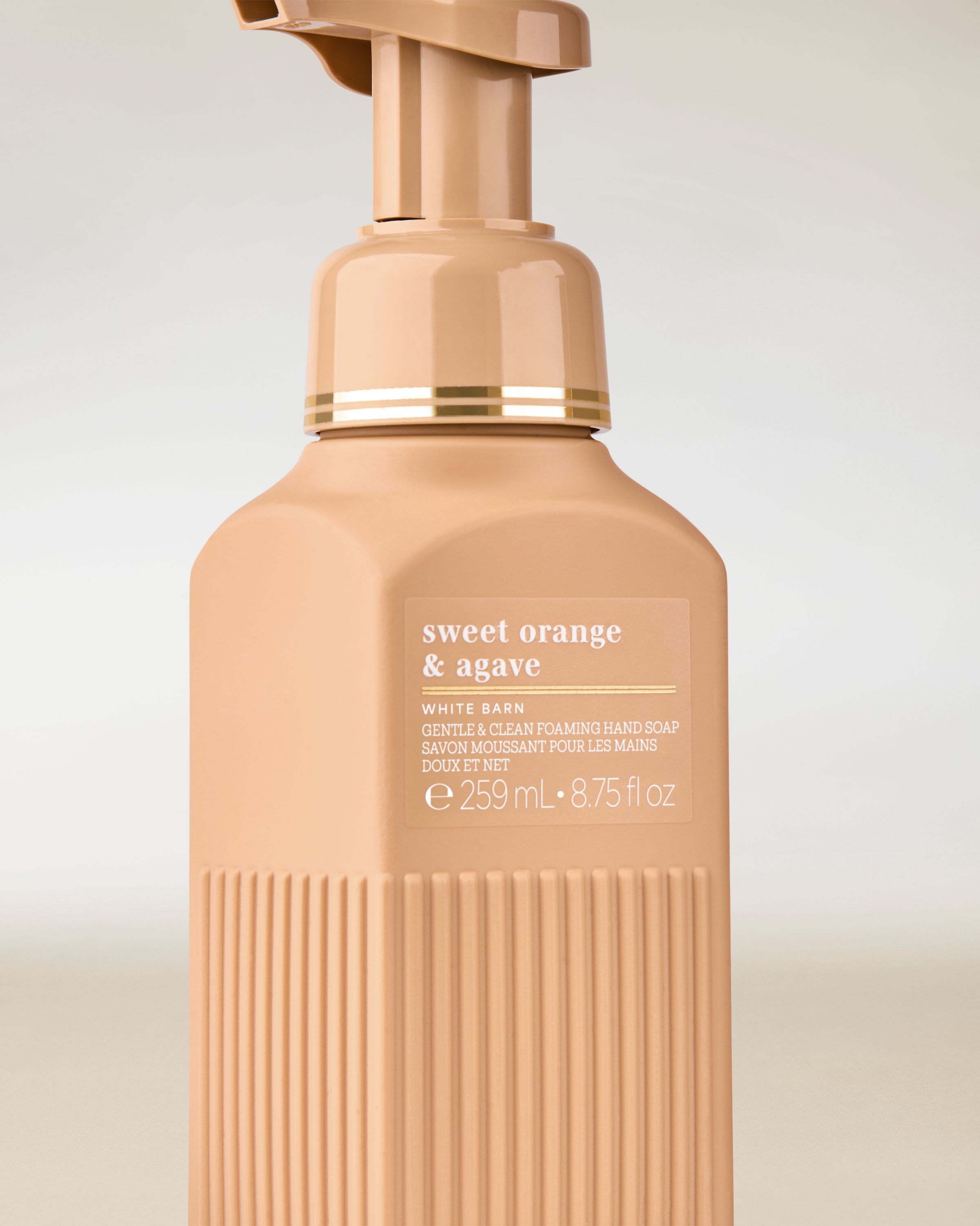 Pěnové mýdlo White Barn „Sweet Orange & Agave“ v meruňkovo‑béžové lahvi s elegantním designem.