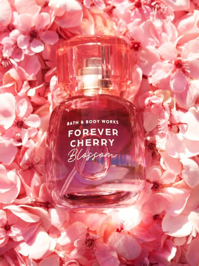 Parfém Bath & Body Works Forever Cherry Blossom v růžovém flakonu na pozadí třešňových květů.
