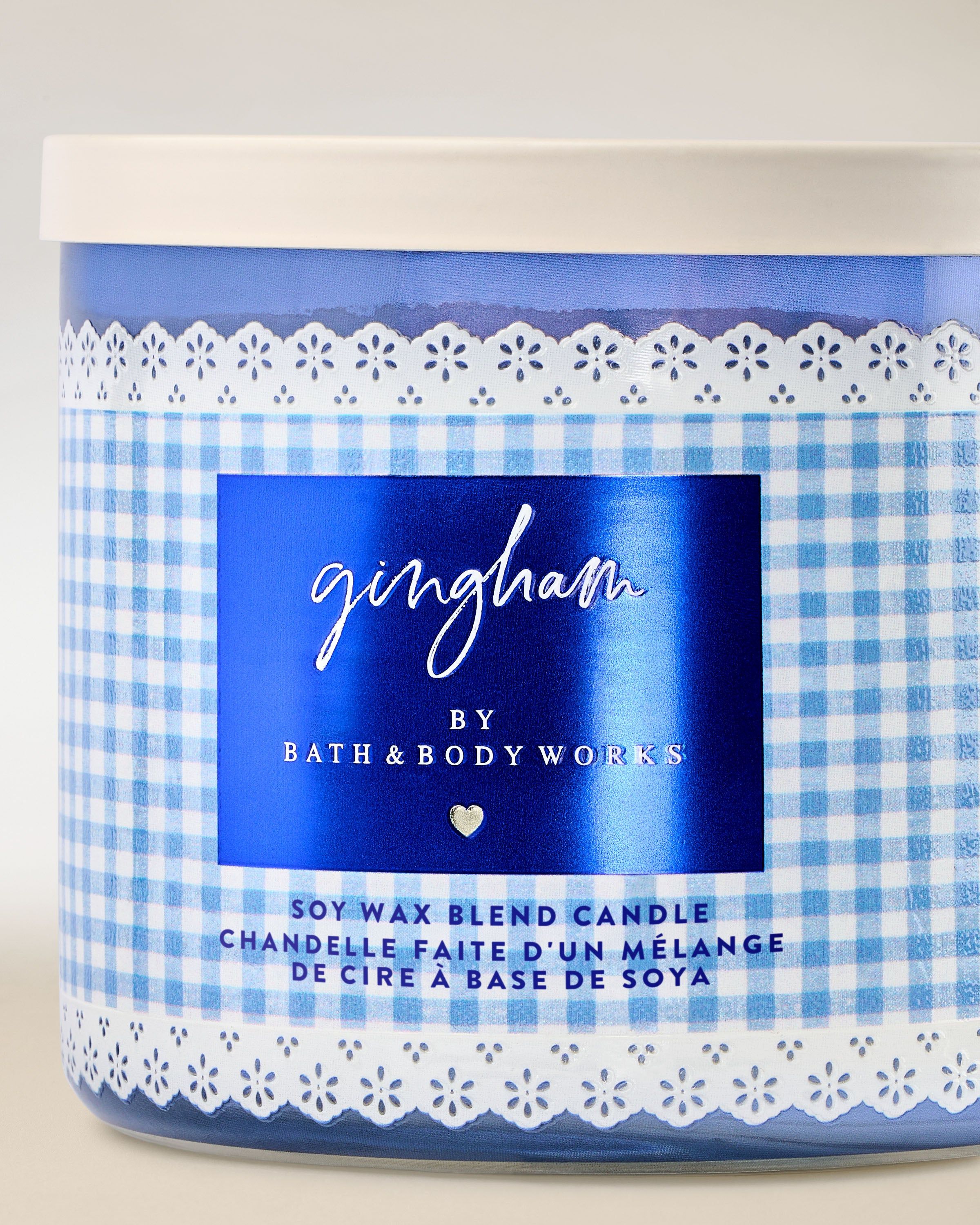 Tříknotová vonná svíčka Bath & Body Works Gingham ve skleněné dóze s modrým gingham vzorem.