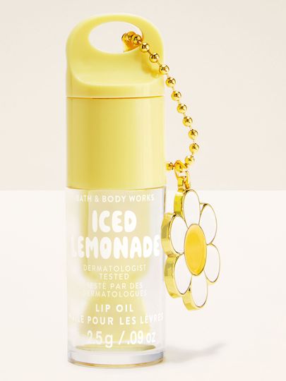 Olej na rty Bath & Body Works Iced Lemonade 2,5 g ve žlutém obalu s ozdobným přívěskem.