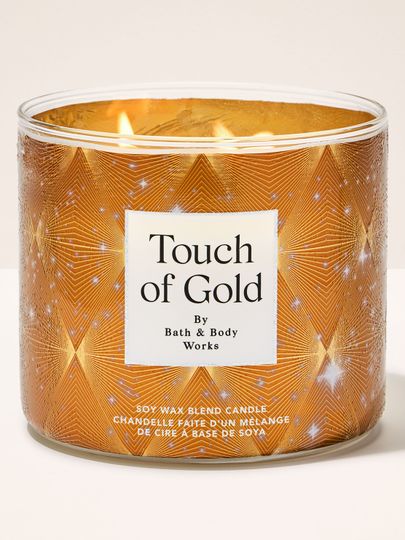 Hořící svíčka se třemi knoty Bath & Body Works Touch of Gold ve zlaté nádobě s Art Deco vzorem.