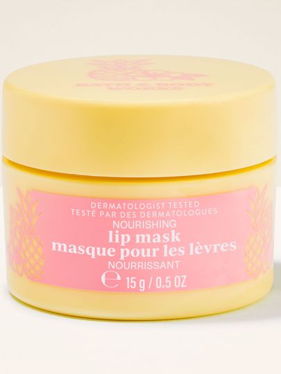 Žlutá dóza Nourishing Lip Mask s růžovou etiketou a ananasovým motivem v čistém produktovém záběru.