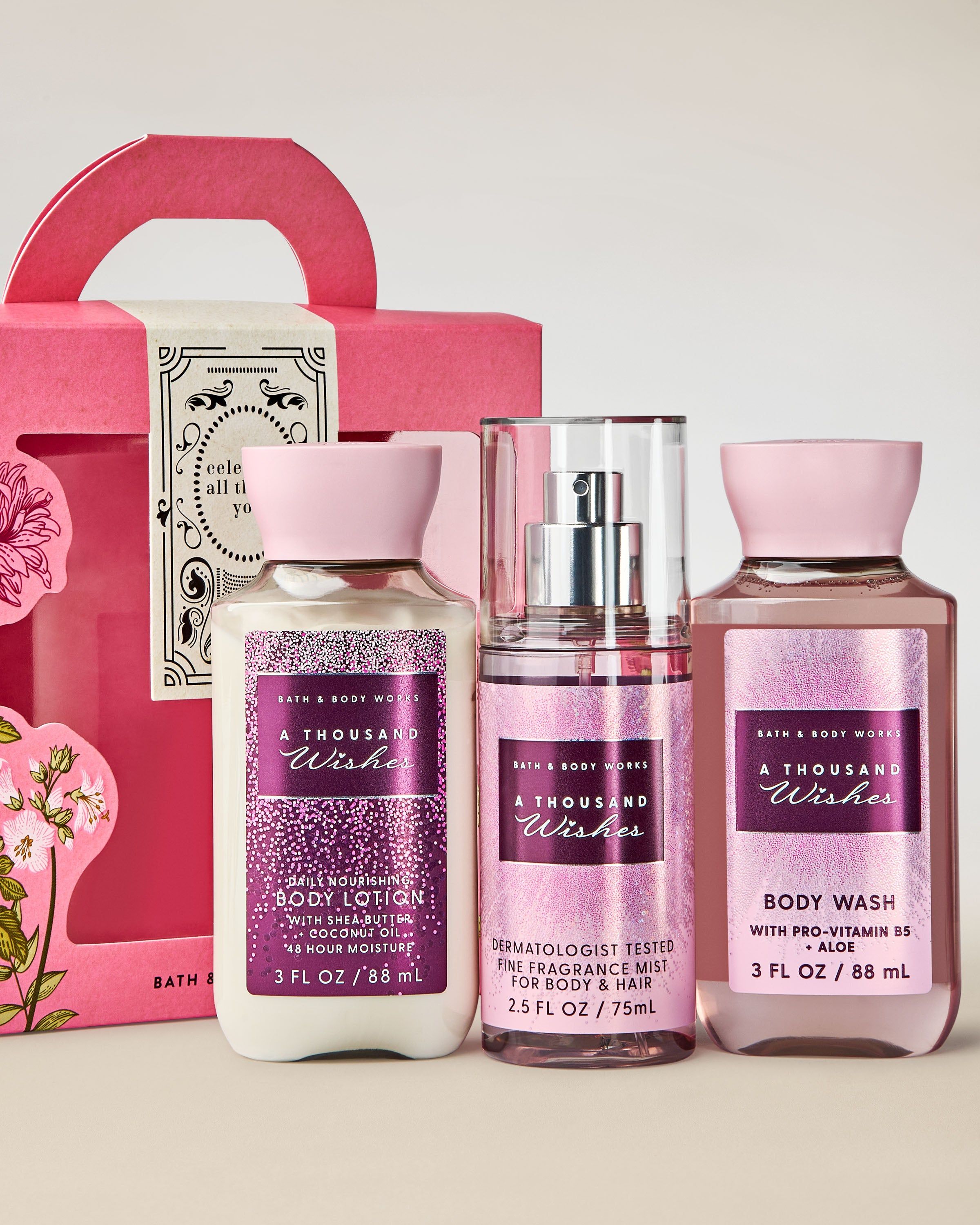 Dárková sada Bath & Body Works A Thousand Wishes s tělovou mlhou, sprchovým gelem a tělovým mlékem v krabičce s uchem.
