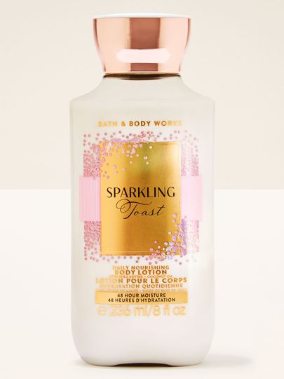 Tělové mléko Sparkling Toast Bath & Body Works v bílé lahvi se zlatou etiketou a růžovými detaily