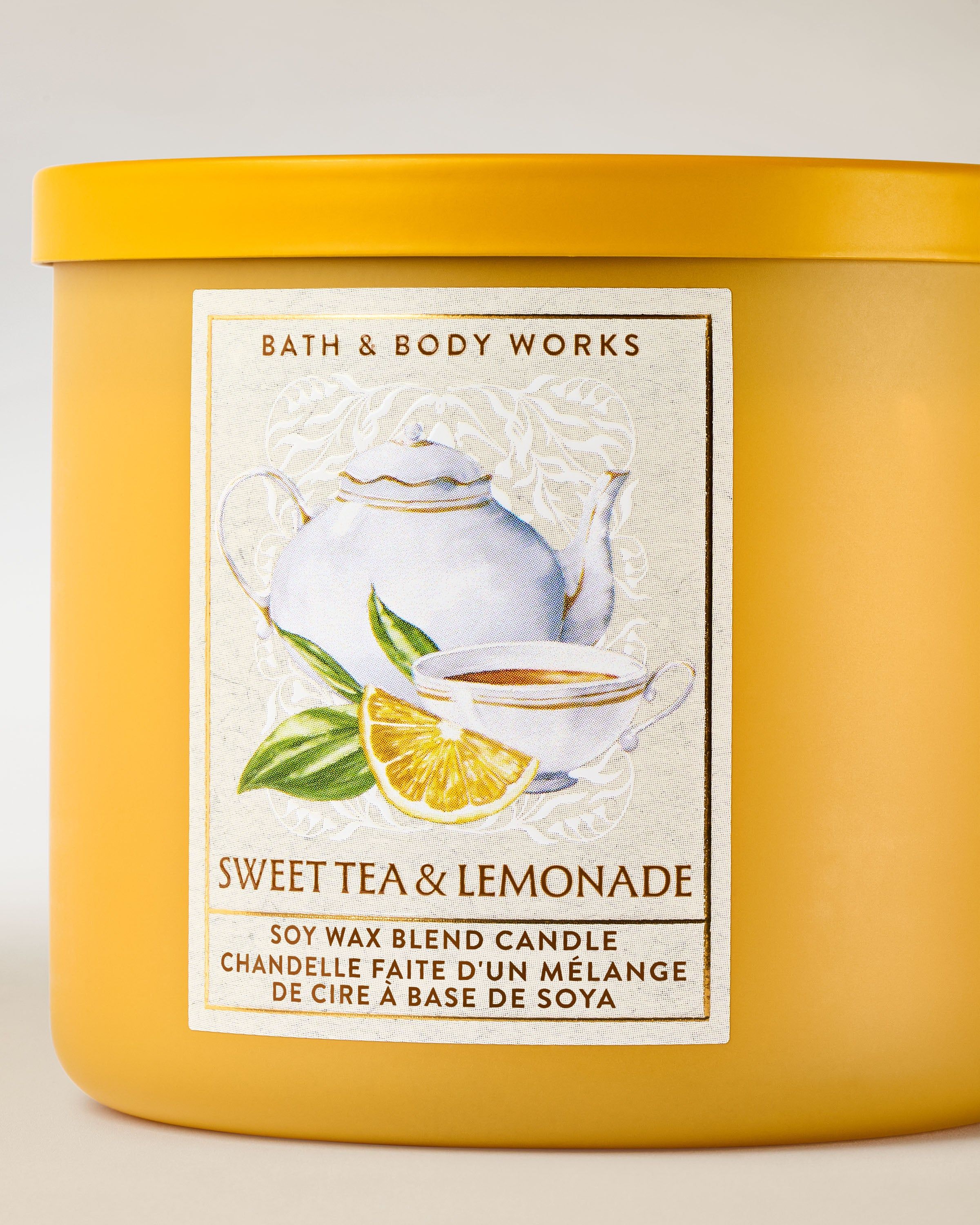 Tříknotová vonná svíčka Bath & Body Works Sweet Tea & Lemonade v matné žluté skleněné dóze.