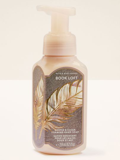 Pěna na ruce Bath & Body Works „Book Loft” — světlá láhev se zlatými pery.