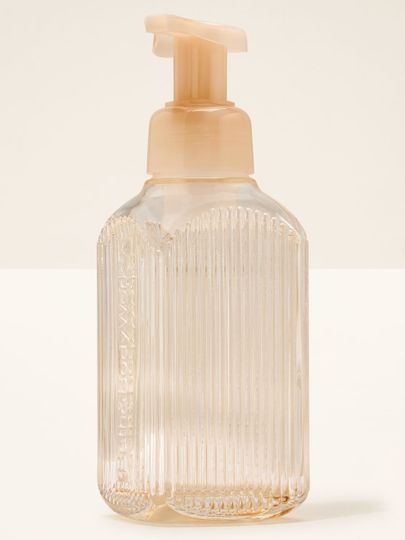 Dávkovač na pěnivé mýdlo Bath&Body Works. Průhledná skleněná nádoba s proužky a béžovým dávkovačem.