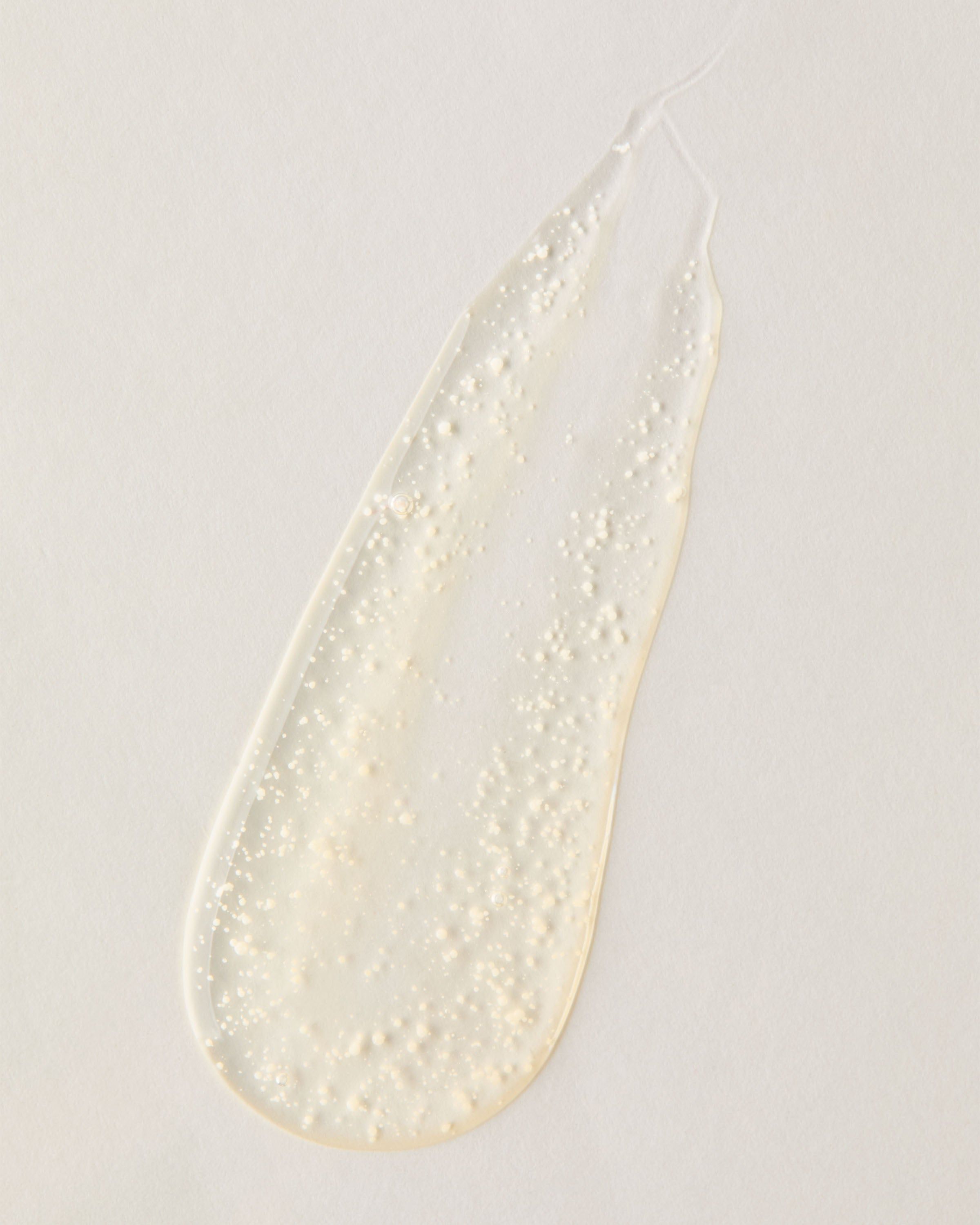 Průhledná vrstva exfoliačního gelu s jemnými částečkami, lehká textura pro čištění pleti.