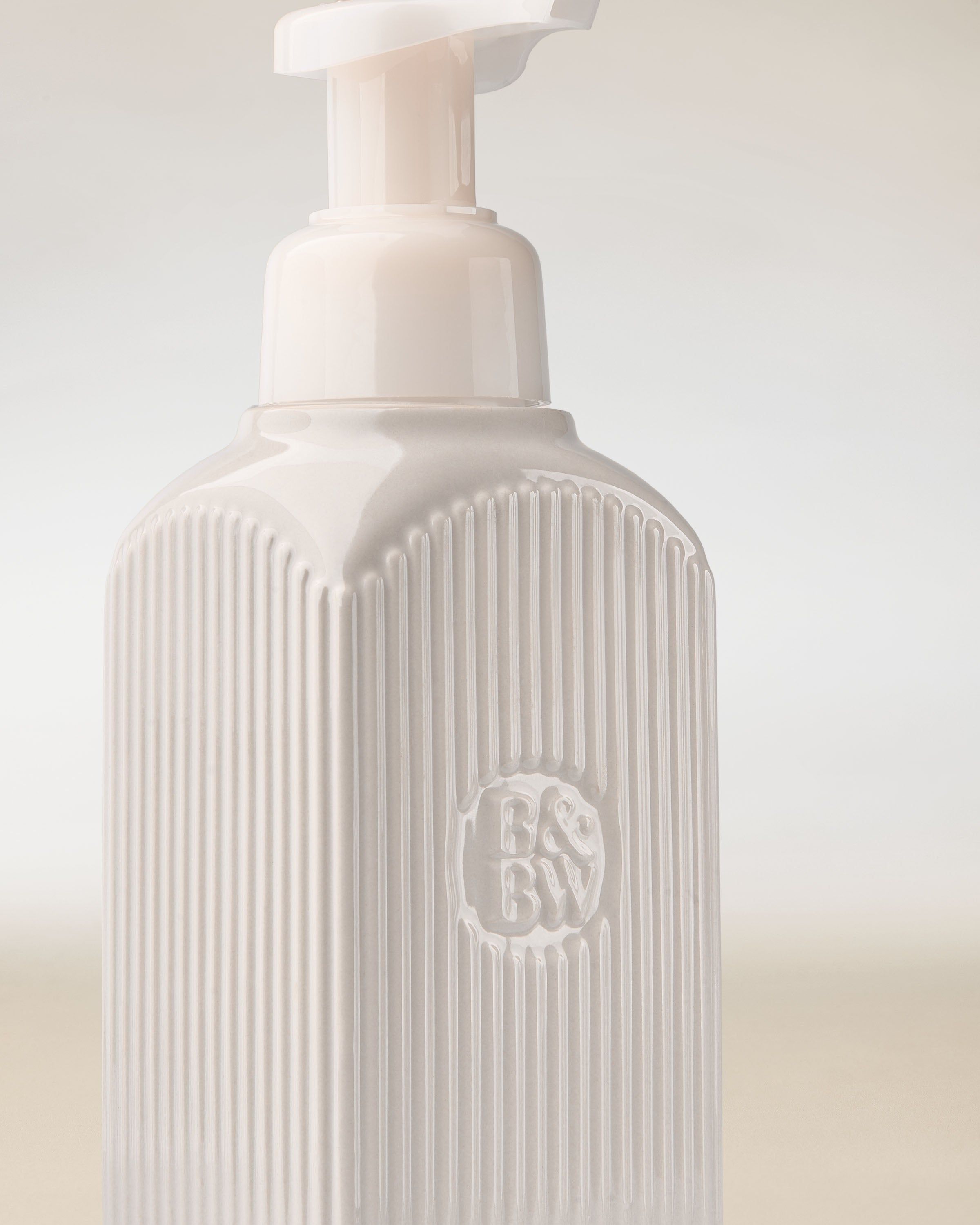 Dávkovač na mýdlo Bath & Body Works v bílé barvě s pumpičkou a reliéfním logem.