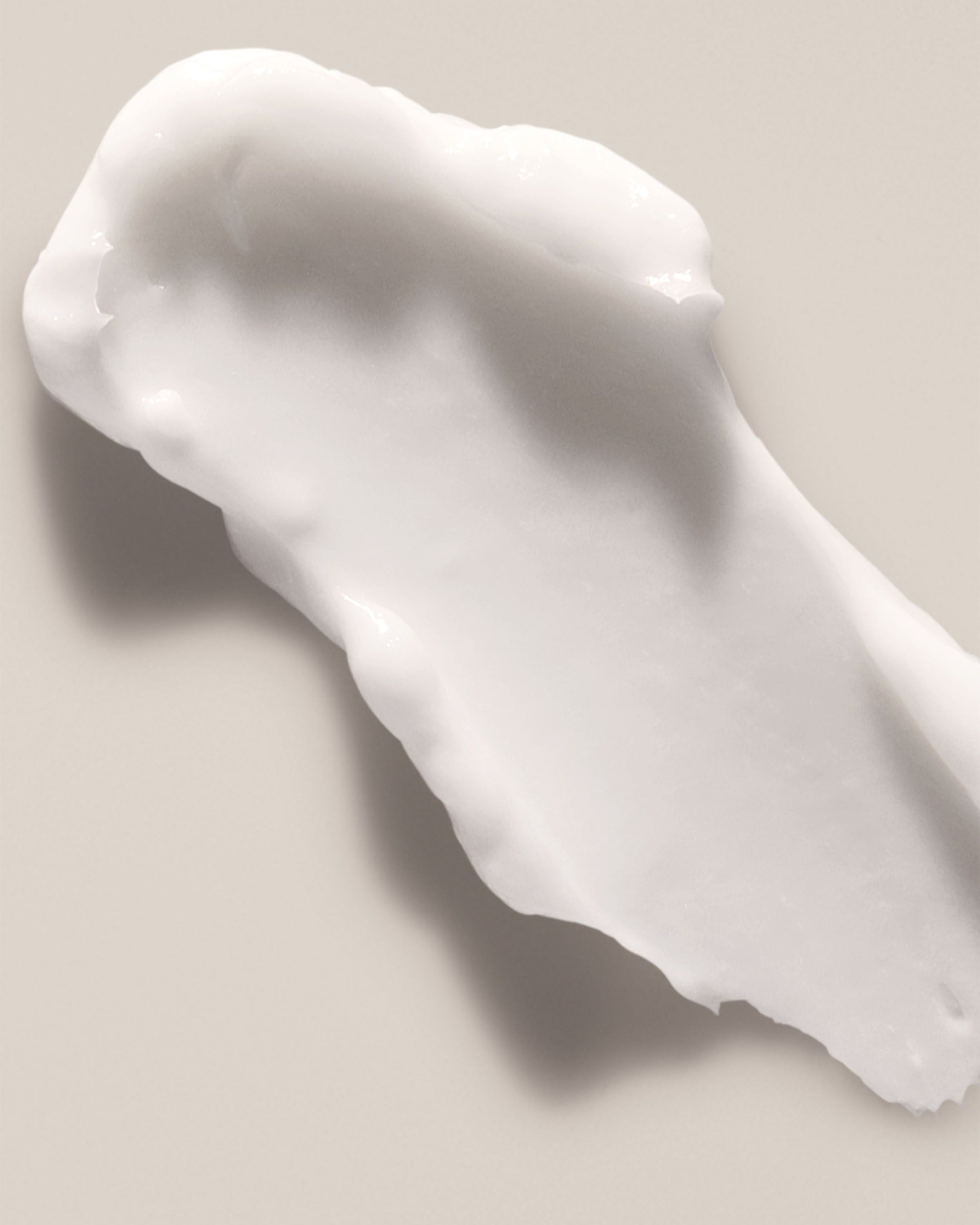 Bílá krémová textura – hladká, vyživující formule pro péči o pokožku.