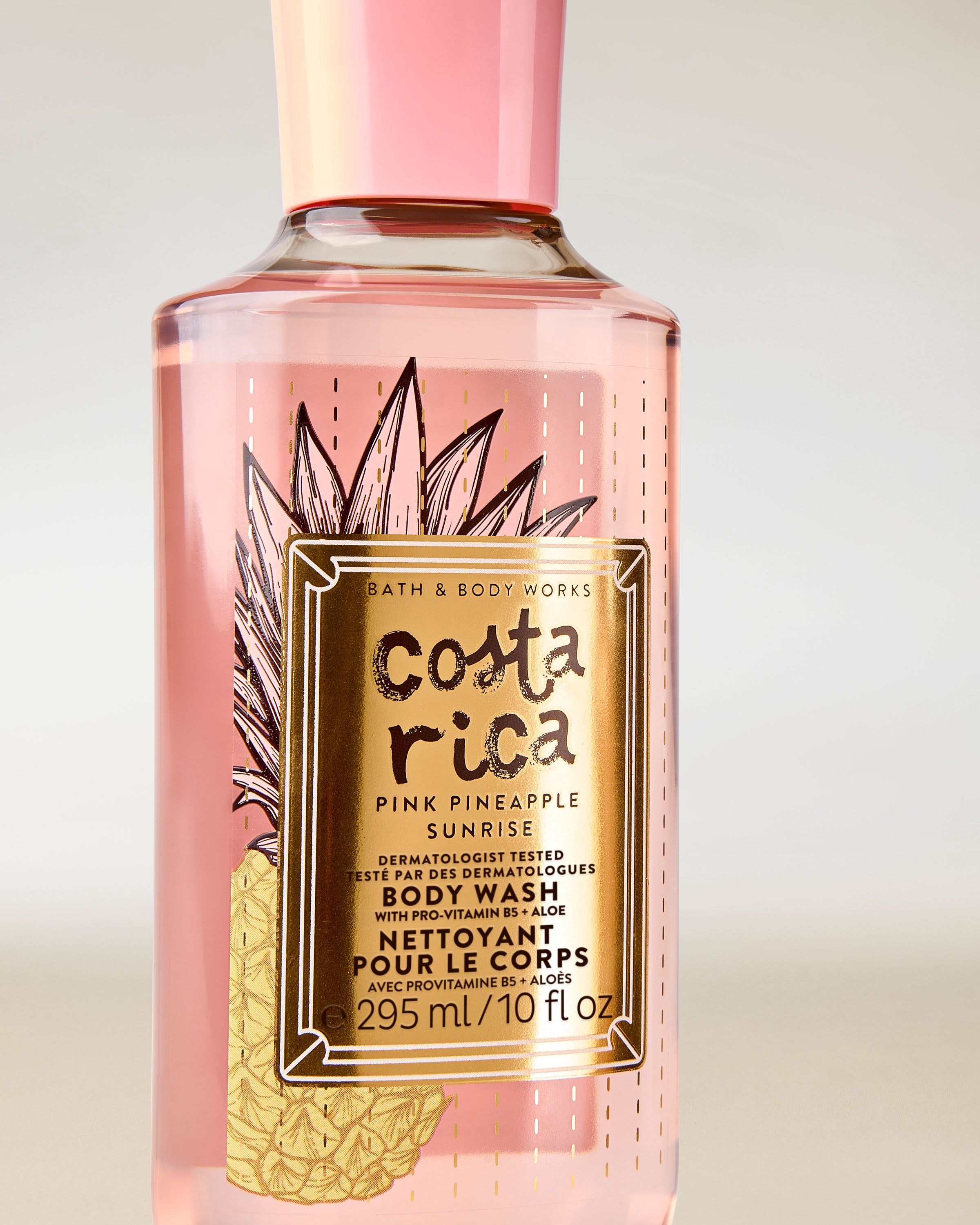Sprchový gel Costa Rica Pink Pineapple Sunrise v růžové lahvi s tropickou etiketou a růžovým víčkem.