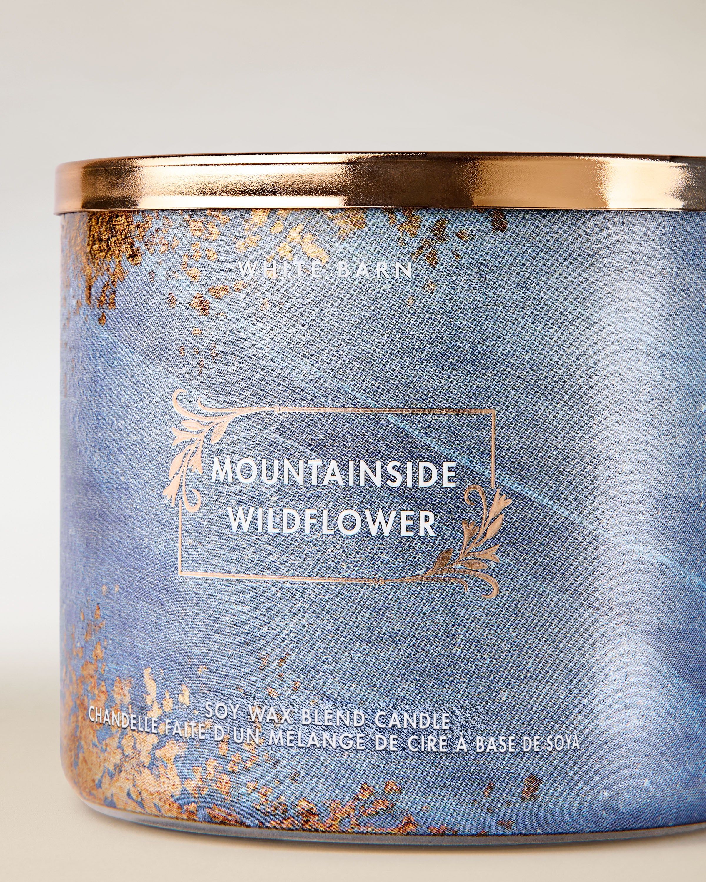 White Barn Mountainside Wildflower – tříknotová svíčka v modrém skle se zlatými detaily, inspirovaná horskými květinami.