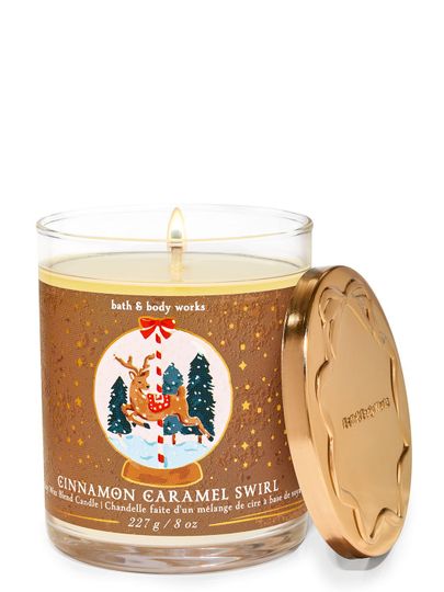 Świeca zapachowa "Cinnamon Caramel Swirl" z etykietą przedstawiającą jelonka w zimowej kuli śnieżnej, Bath & Body Works.