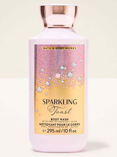 Růžový sprchový gel Sparkling Toast Bath & Body Works v lahvi s růžovo‑zlatou etiketou