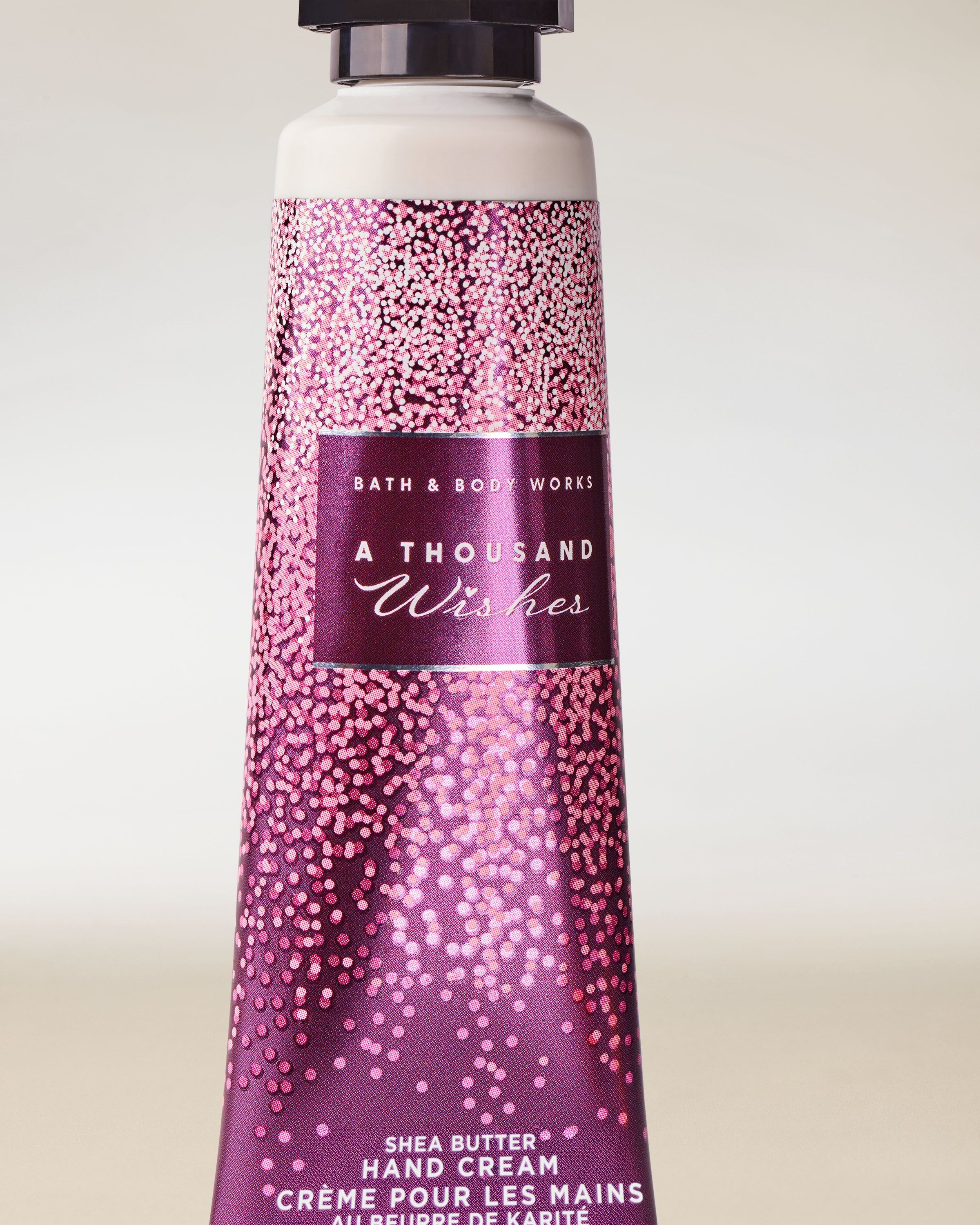 Krém na ruce Bath & Body Works A Thousand Wishes v růžovo‑fialové tubě, 29 ml.