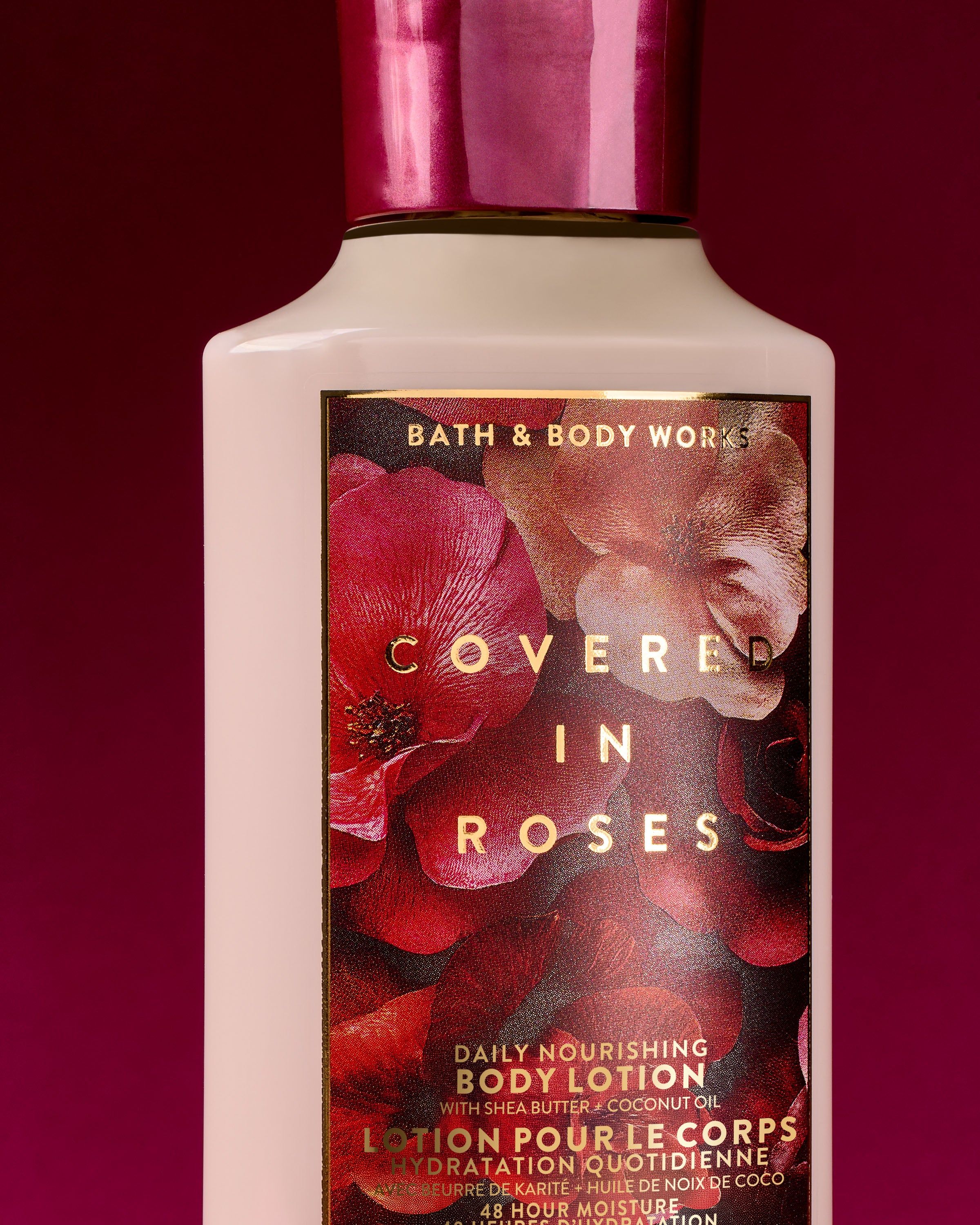 Bath & Body Works Covered in Roses – tělové mléko v krémové lahvi na vínovém pozadí.