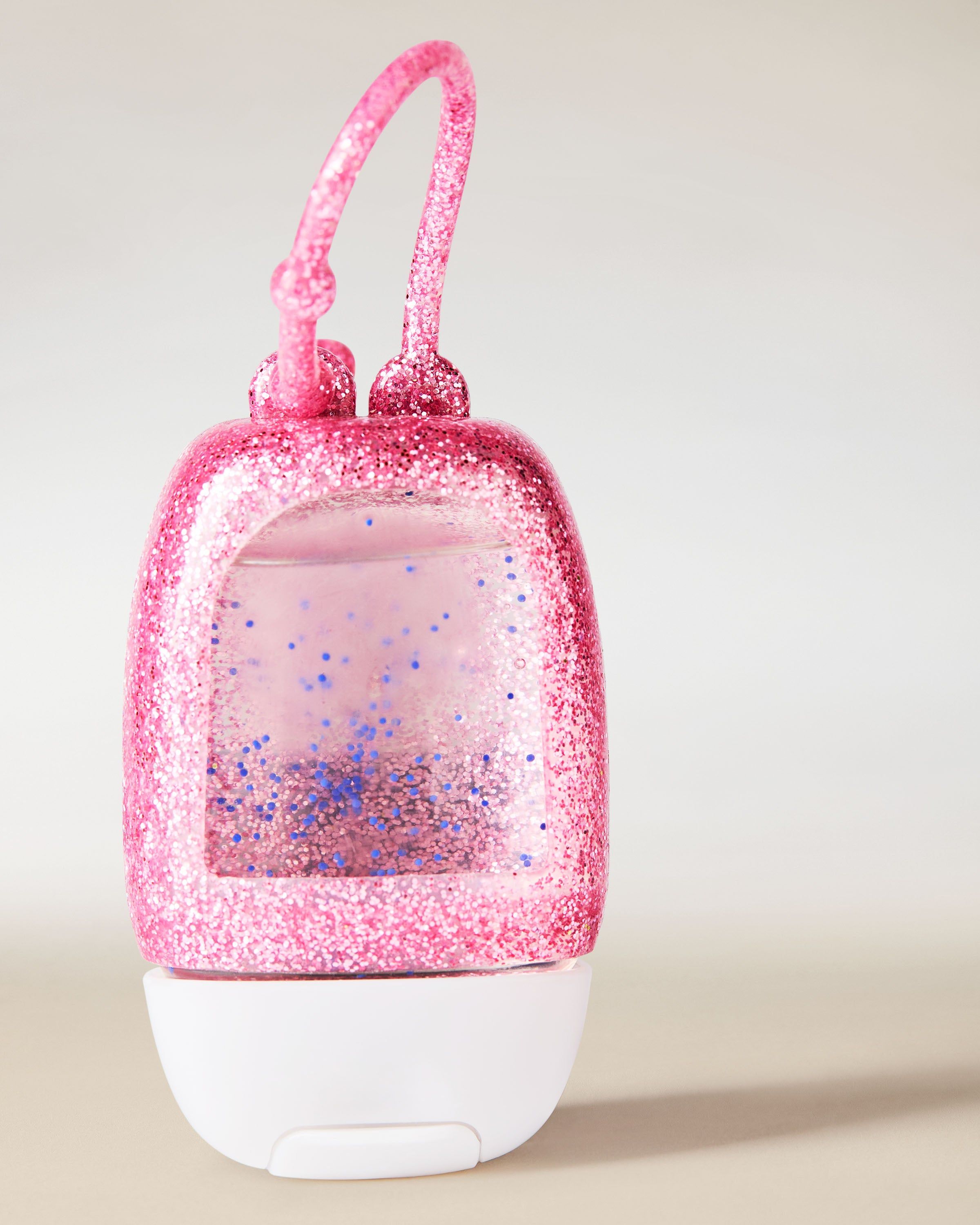 Třpytivý růžový držák na PocketBac z pružného materiálu, určený pro snadné uchycení mini dezinfekčního gelu.