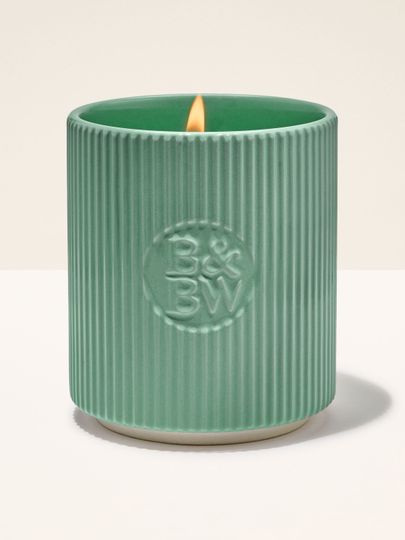 Svíčka Bath & Body Works v zeleném keramickém držáku s rýhovaným povrchem.