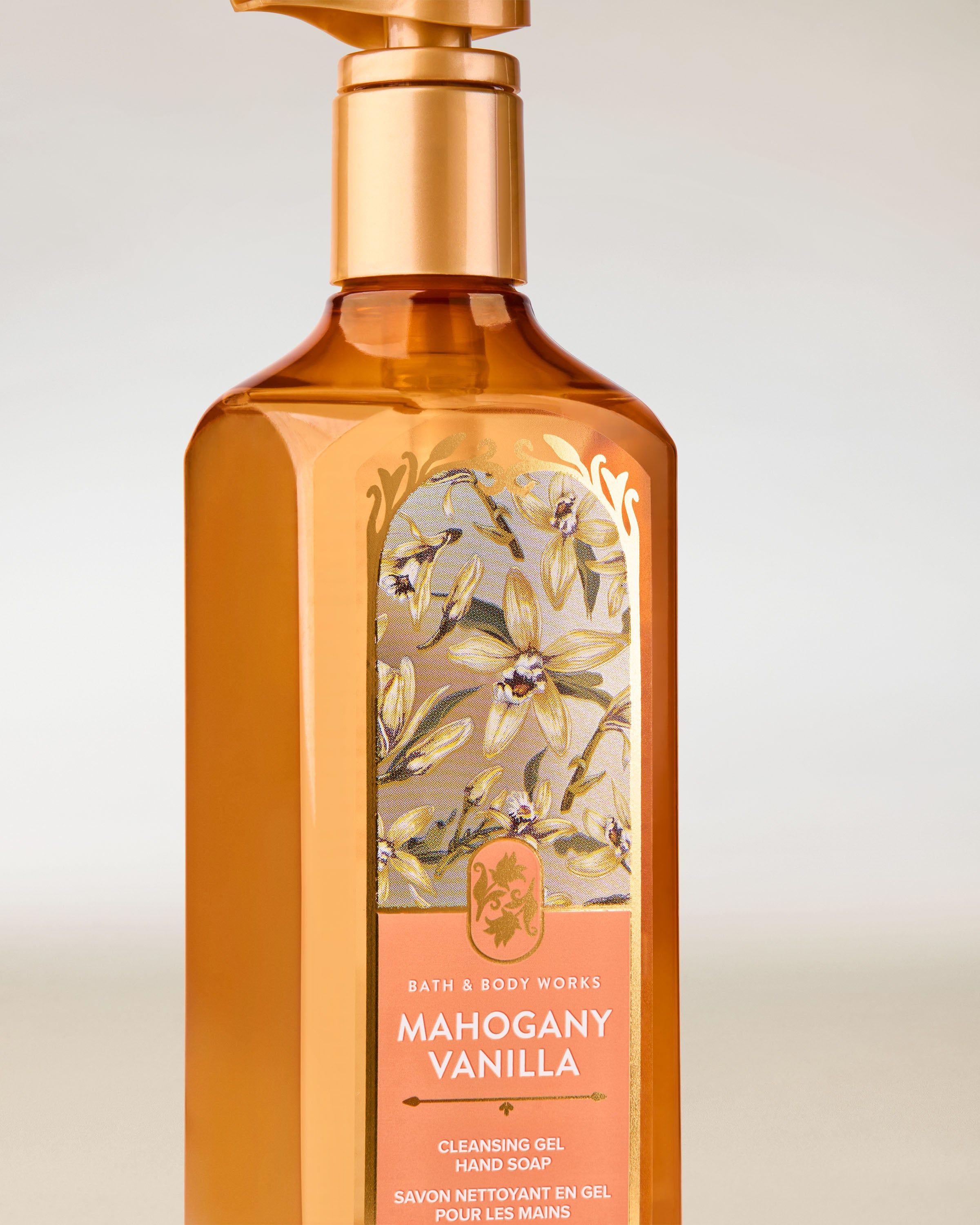 Gel na ruce Bath & Body Works „Mahogany Vanilla” — jantarová láhev s elegantním květinovým motivem.