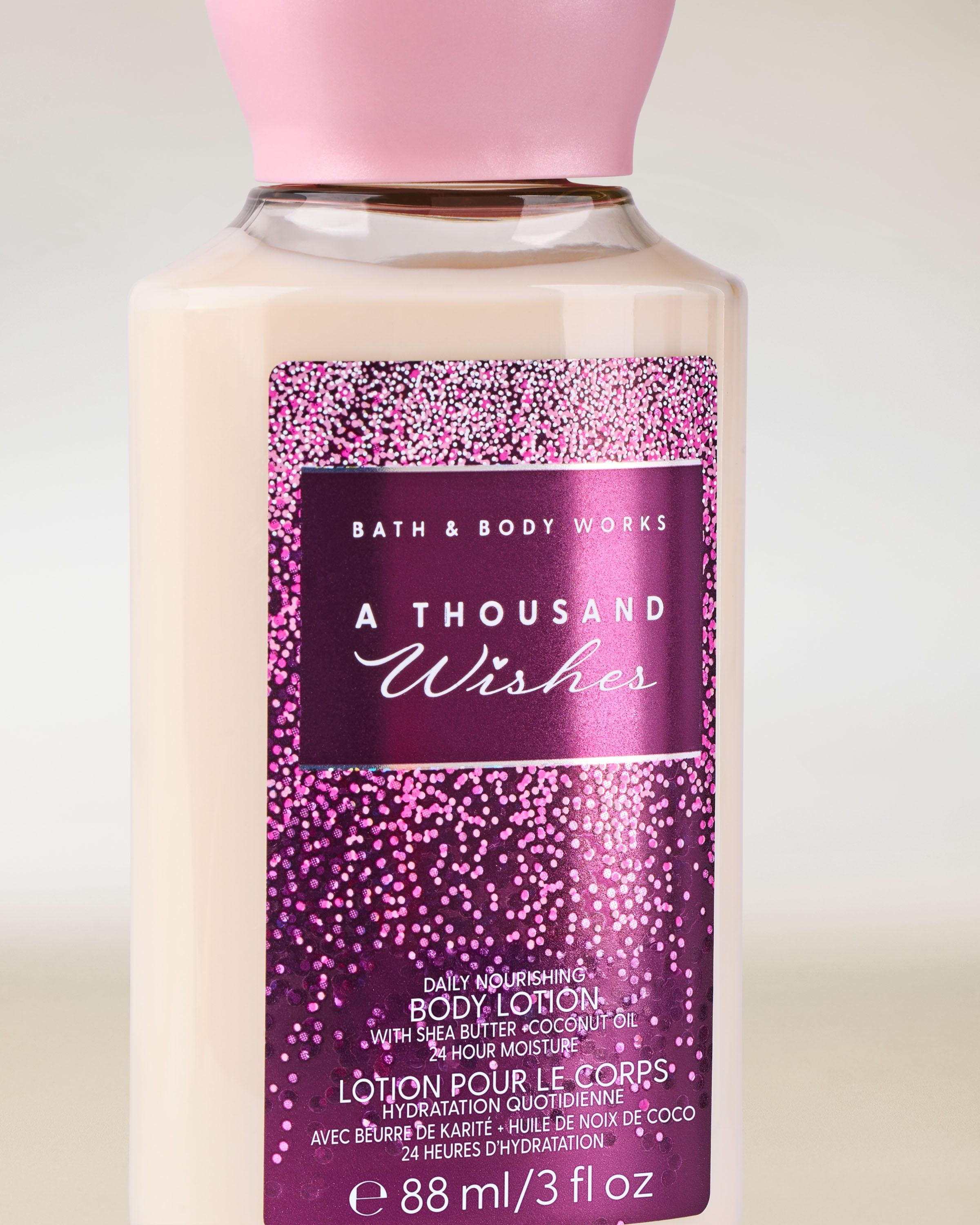Mini tělové mléko Bath & Body Works A Thousand Wishes s růžovo‑fialovou třpytivou etiketou.