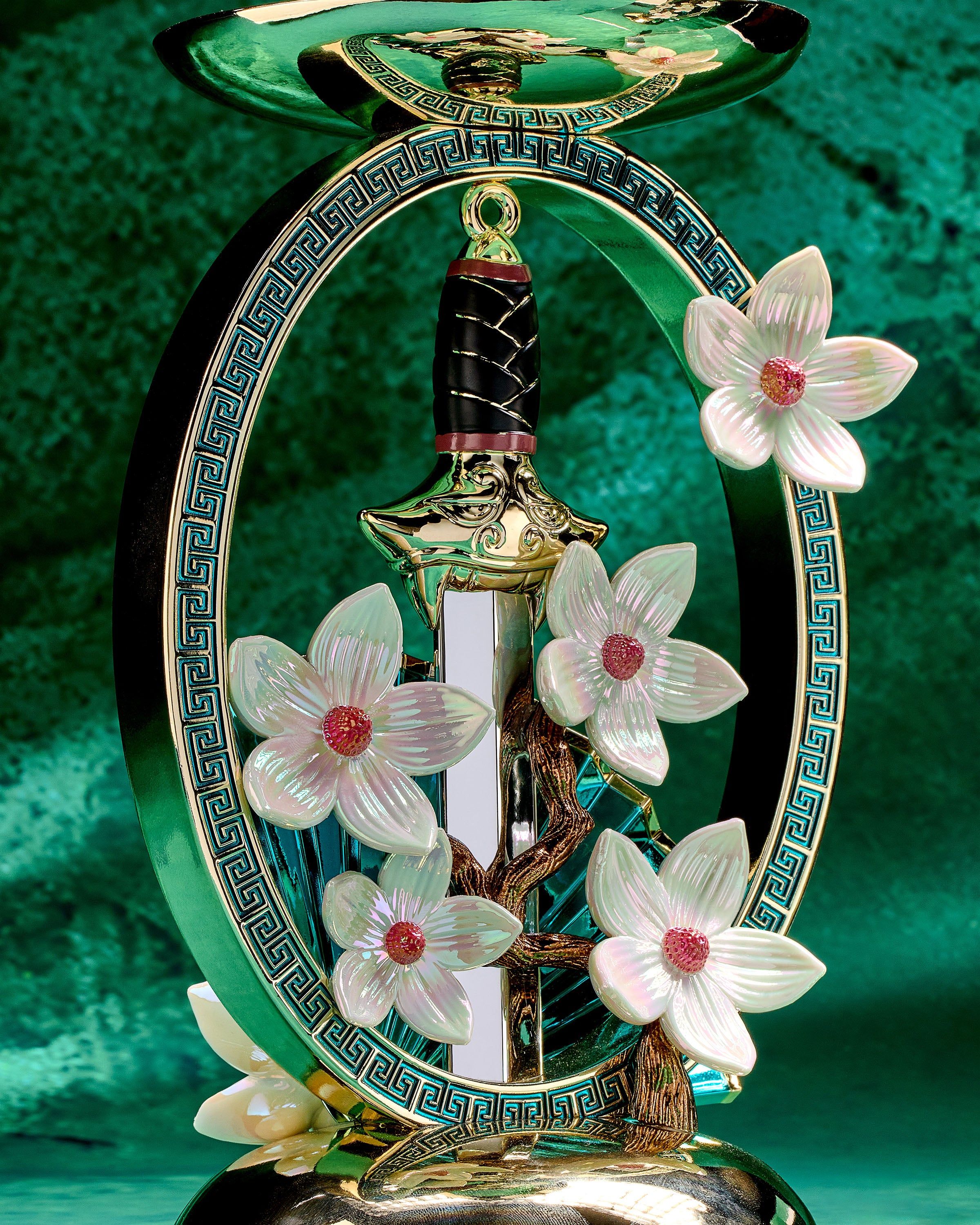 Stojánek Mulan na 3knotovou svíčku se zlatým mečem, vějířem a květy magnolií v ozdobném rámu.