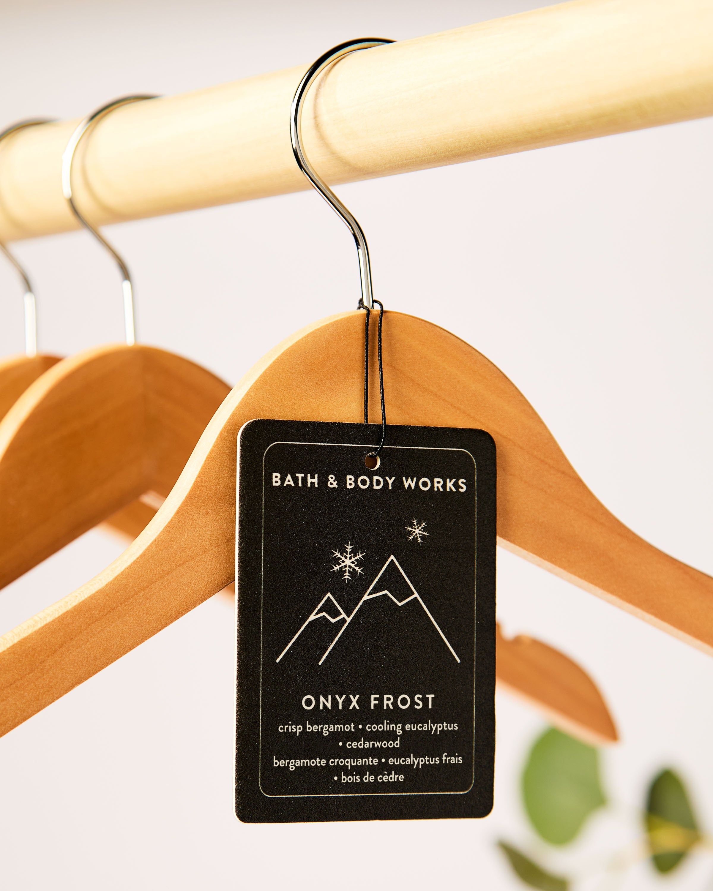 Vůně do auta Onyx Frost od Bath & Body Works v lifestyle záběru, zavěšená na dřevěném ramínku.