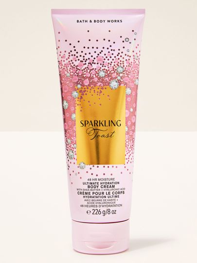 Tělový krém Sparkling Toast Bath & Body Works v růžové tubě se zlatou třpytivou etiketou