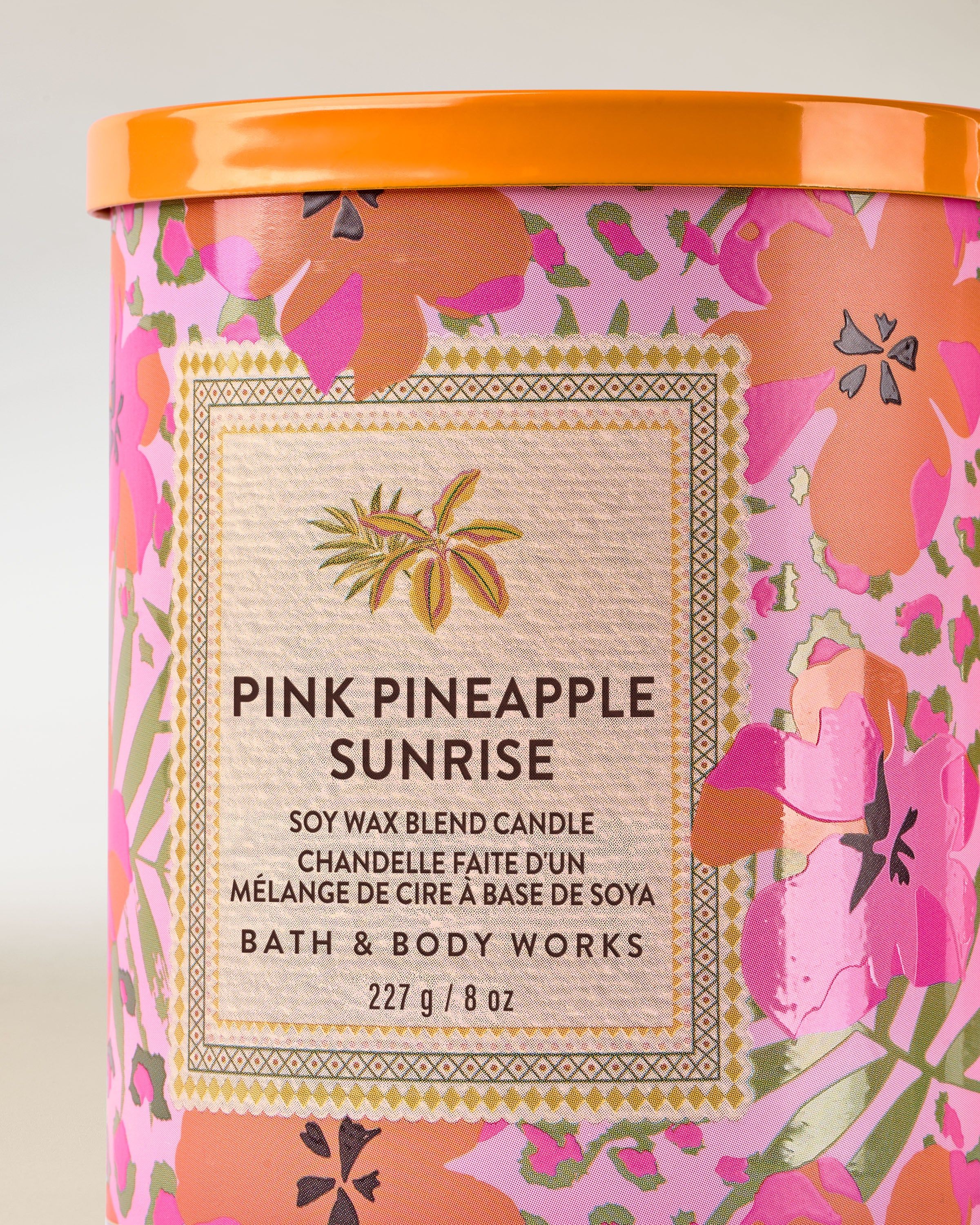 Svíčka Pink Pineapple Sunrise s barevnou tropickou etiketou s hibiskusy a ananasem – svěží letní styl.