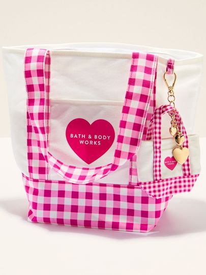 Taška Bath & Body Works s růžovo‑bílým gingham vzorem, uchy a ozdobným přívěskem.