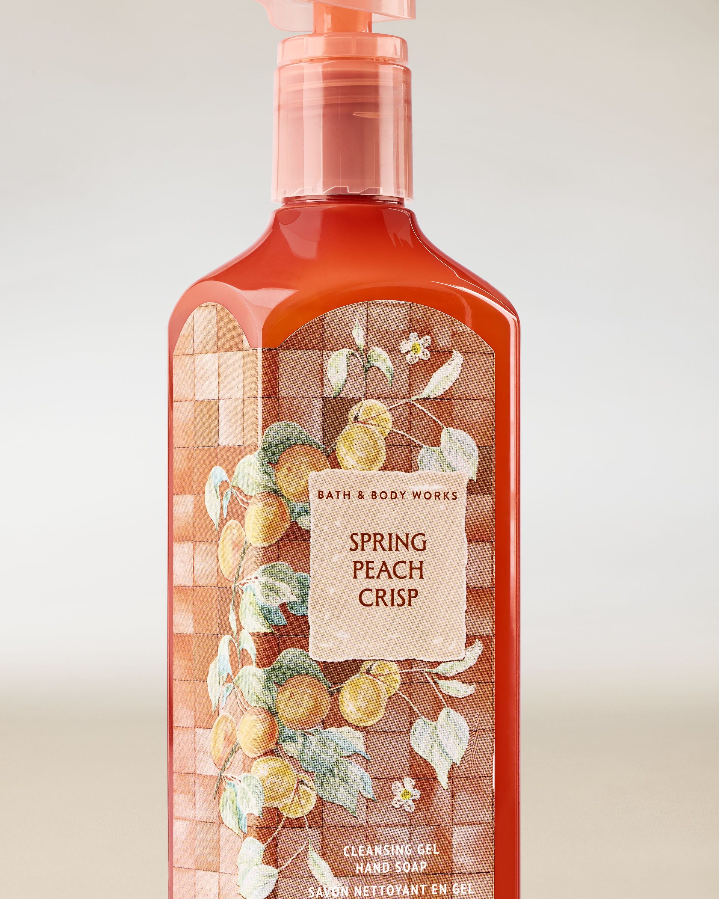 Gel na mytí rukou Bath & Body Works Spring Peach Crisp 236 ml v korálové lahvi s motivem broskví.