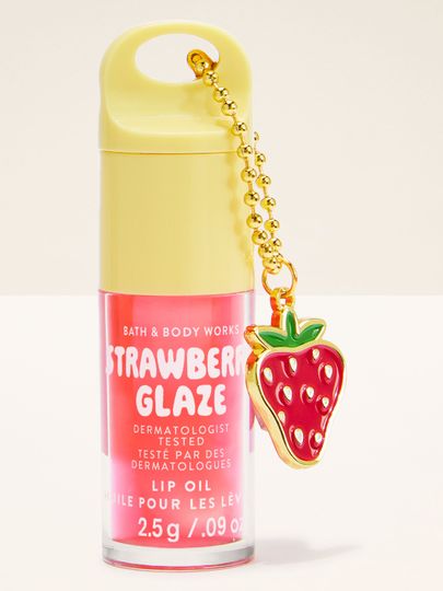 Olej na rty Bath & Body Works Strawberry Glaze 2,5 g v růžovém obalu s přívěskem ve tvaru jahody.