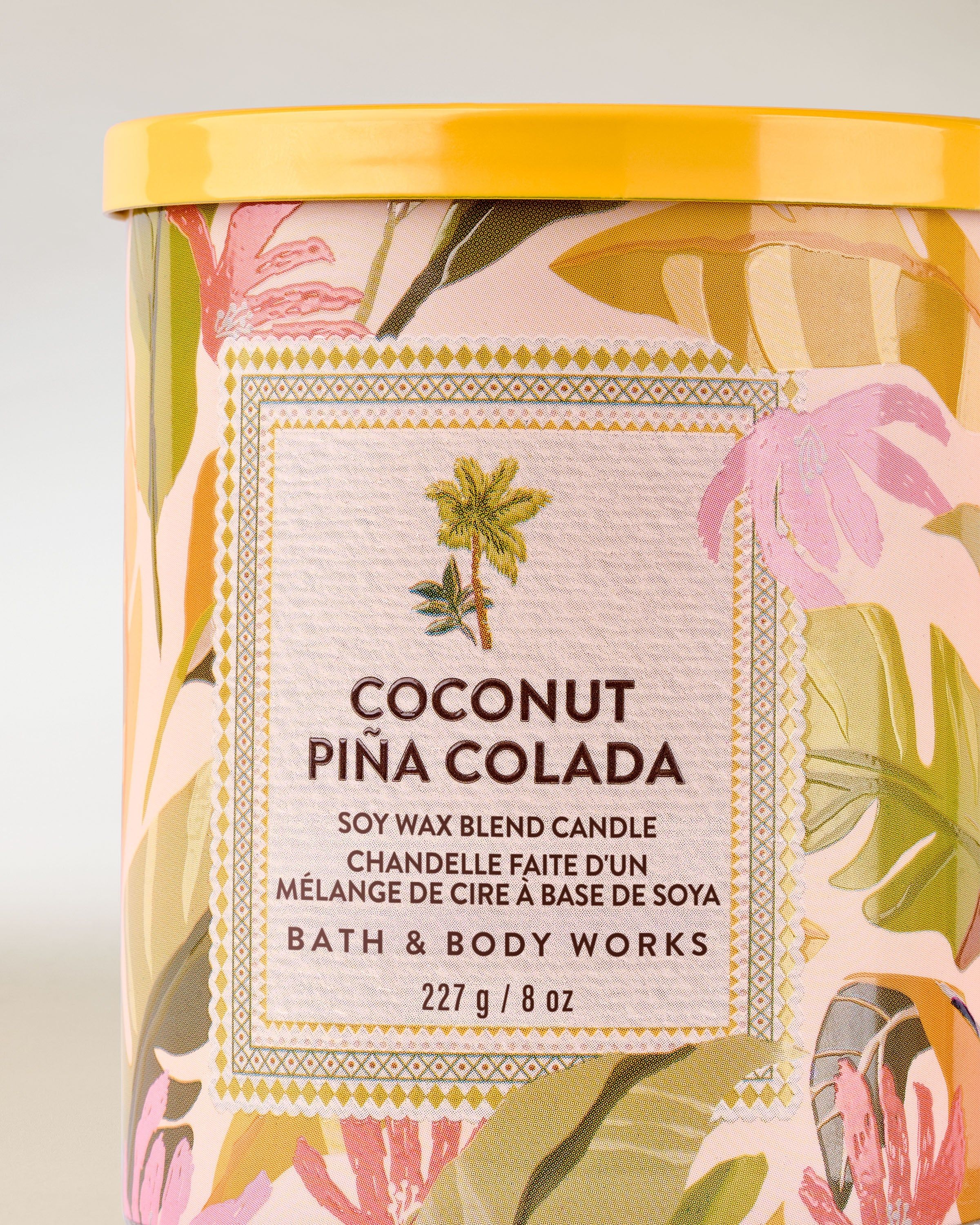 Vonná svíčka Coconut Piña Colada od Bath & Body Works ve skleněné nádobě s barevnou tropickou etiketou.