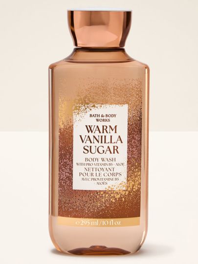 Sprchový gel "Warm Vanilla Sugar" v oranžové lahvi s třpytivou etiketou Bath & Body Works.