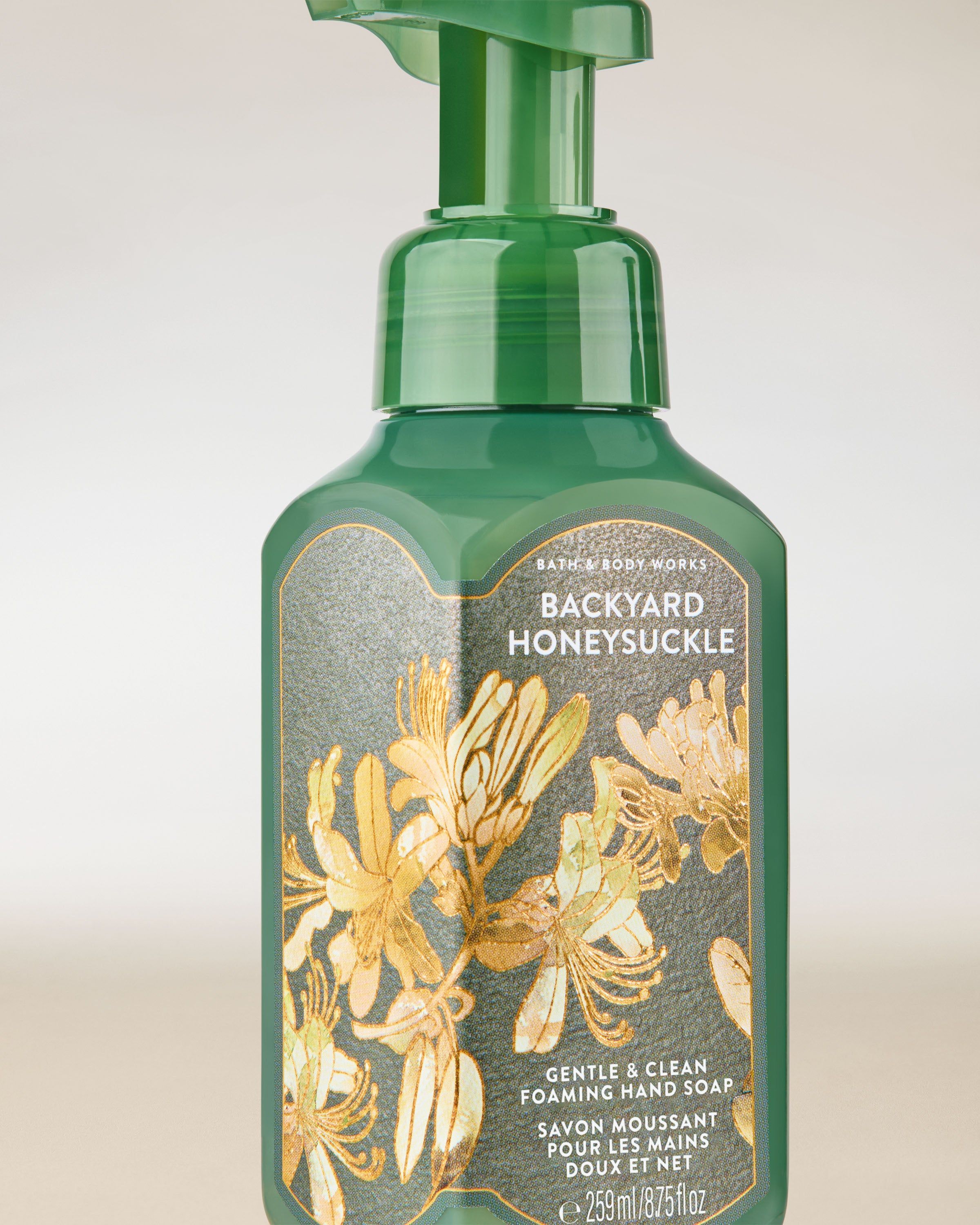 Pěna na ruce Bath & Body Works „Backyard Honeysuckle” — zelená láhev se zlatými květy.