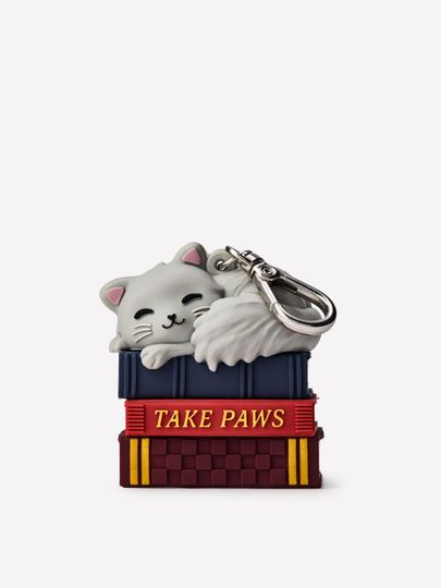 Pouzdro na antibakteriální gel na ruce ve tvaru spící kočky na stohu knih s kovovou karabinou