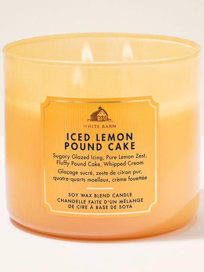 Tříknotová vonná svíčka White Barn Iced Lemon Pound Cake v matné žluté skleněné dóze.