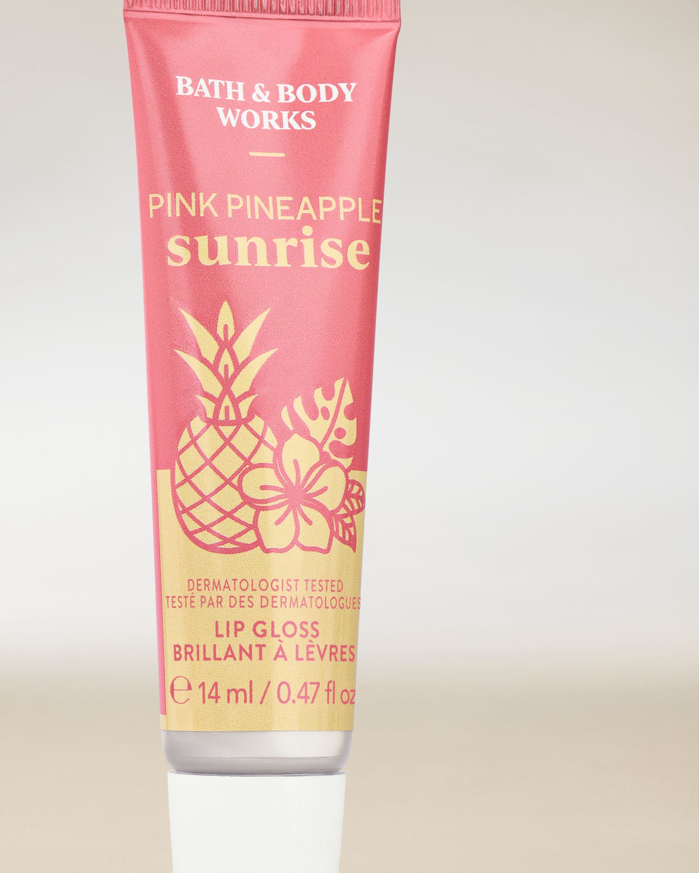 Pink Pineapple Sunrise – lesk na rty v růžové tubě s tropickým motivem ananasu a ibišku.