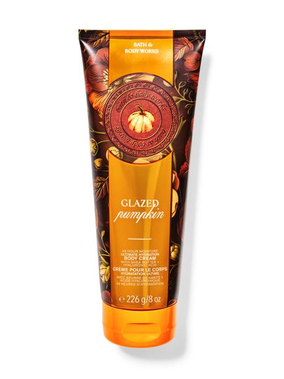 Tělový krém Bath&Body Works Glazed Pumpkin. Velká, kovová tuba v oranžovo-hnědé barvě s dýní a nápisy.